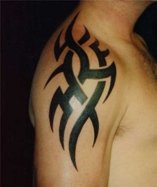 A tribal tattoo on man's right upper arm.