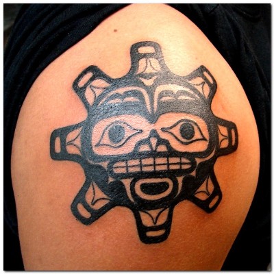 A special tribal sun tattoo on man's arm.