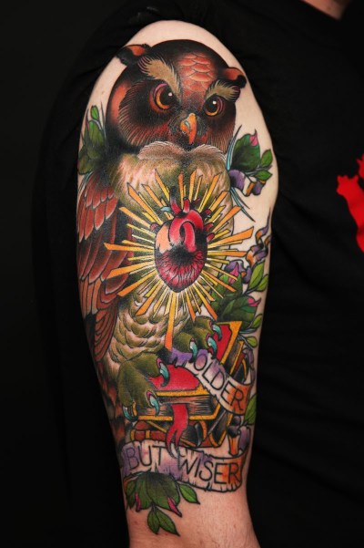 An incredible owl tattoo on man's arm.